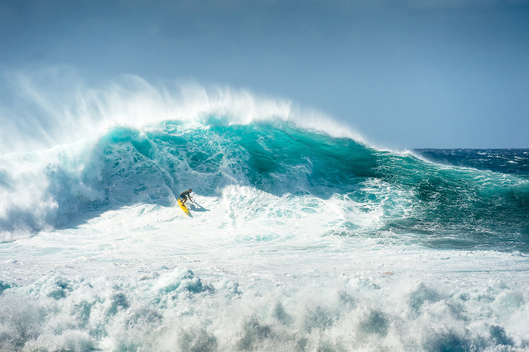 Kohl Christensen riding a mountain of water on a chaotic day at Pipeline on the north shore of Oahu, Hawaii.